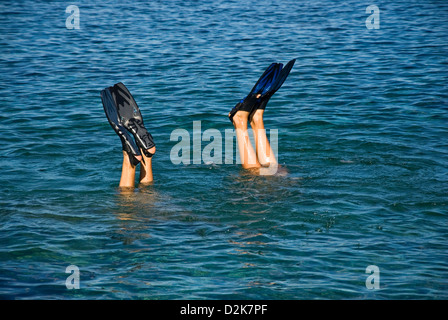 Beine von zwei Tauchern mit flossen aus dem Meer schweben Stockfoto