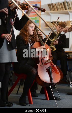 Ein Mädchen mit einem Cello während einer Orchester-Praxis an der Pasteten Grammar School in Cheltenham, Gloucestershire UK Stockfoto