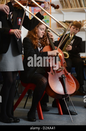 Ein Mädchen mit einem Cello während einer Orchester-Praxis an der Pasteten Grammar School in Cheltenham, Gloucestershire UK Stockfoto