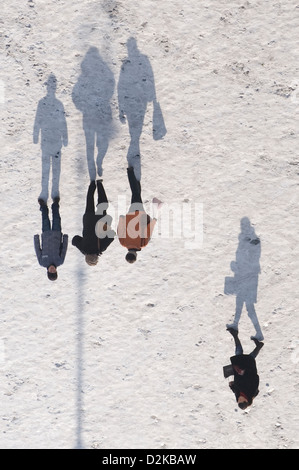 Dresden, Deutschland, Männer werfen lange Schatten auf den verschneiten Neumarkt Stockfoto