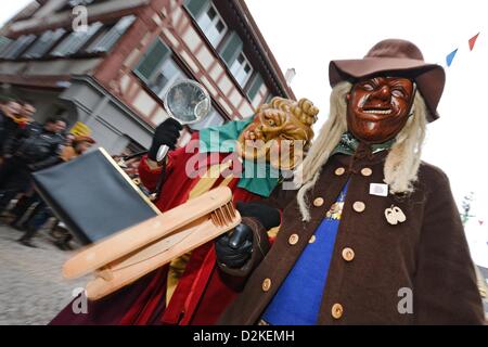 Dutzende von Menschen vor Ort traditionelle Masken und Kostüme tragen teilnehmen an einem Karnevalsumzug in Bad Saulgua, Deutschland, 27. Januar 2013. Mehr als 7.000 Menschen nahmen an der Veranstaltung teil. Foto: FELIX KAESTLE Stockfoto