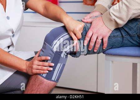 Der Arzt stellt auf den Mann Klammer Beinen Stockfoto