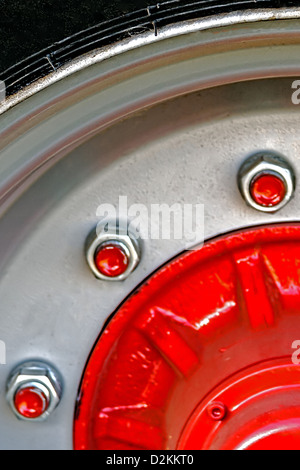 Große rote Felge mit Schrauben, für Maschinen in der Landwirtschaft eingesetzt. Detail Stockfoto