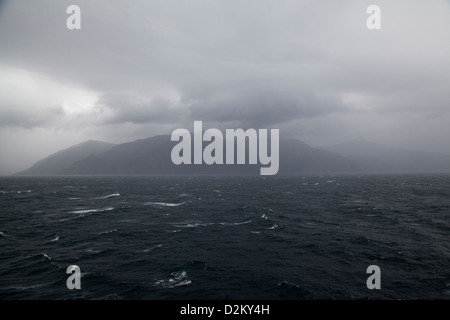 Sonne Licht fängt einen steigenden Nebel entlang der Klippen der Klänge in Neuseeland. Stockfoto