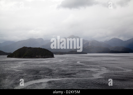 Sonne Licht fängt einen steigenden Nebel entlang der Klippen der Klänge in Neuseeland. Stockfoto