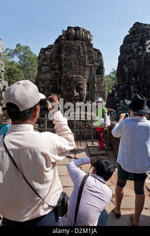 Touristen fotografieren das Gesicht Türme. Bayon Tempel. Angkor. Kambodscha Stockfoto