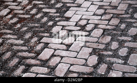 Hintergrundtextur von beschädigten alten gepflasterten Straße Stockfoto