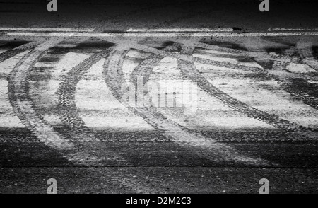 Drehen nasse Reifenspuren und Strichmarkierung auf der Asphaltstraße Stockfoto