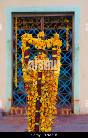 Dekorative Blumen bekränzt Trident vor einen hindu-Tempel. Andhra Pradesh, Indien Stockfoto