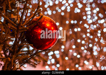 Rote Dekoration Kugel und Girlanden auf einen Weihnachtsbaum mit Schnee bedeckt Stockfoto