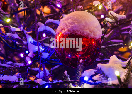 Rote Dekoration Kugel und Girlanden auf einen Weihnachtsbaum mit Schnee bedeckt Stockfoto