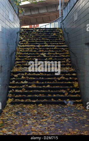 Schritte von einem der Hulme u-Bahnen in Herbstlaub abgedeckt. Die u-Bahn kann Fußgänger unter die Mancunian Weise zu überqueren. Stockfoto