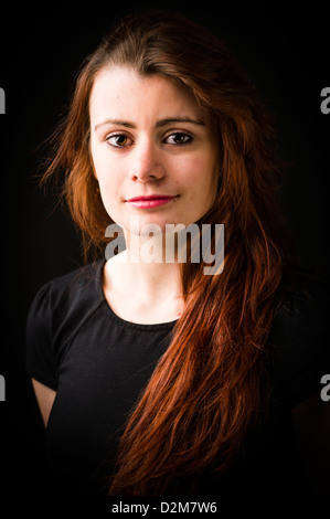 Eine neunzehnjährige Mädchen junge Frau, mit langen braunen Haaren, UK, schwarzer Hintergrund Stockfoto