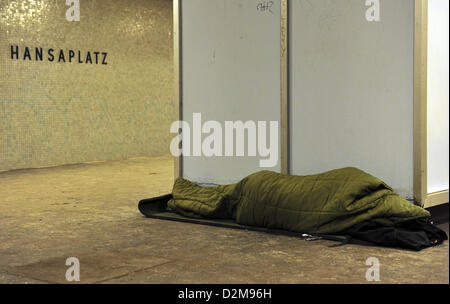 Ein Obdachloser ruht auf einer Bank in einer u-Bahnstation in Berlin, Deutschland, 24. Januar 2013. Aufgrund der eisigen Kälte Obdachlose Havbe Zuflucht in Lobby-Bereichen der Banken und Bahnhöfe. Foto: Paul Zinken Stockfoto