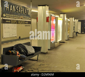 Ein Obdachloser ruht auf einer Bank in einer u-Bahnstation in Berlin, Deutschland, 24. Januar 2013. Aufgrund der eisigen Kälte Obdachlose Havbe Zuflucht in Lobby-Bereichen der Banken und Bahnhöfe. Foto: Paul Zinken Stockfoto