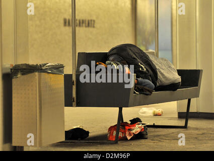 Ein Obdachloser ruht auf einer Bank in einer u-Bahnstation in Berlin, Deutschland, 24. Januar 2013. Aufgrund der eisigen Kälte Obdachlose Havbe Zuflucht in Lobby-Bereichen der Banken und Bahnhöfe. Foto: Paul Zinken Stockfoto
