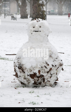 Schneemann mit Zweigen für Arme in den Schnee in London Felder Hackney Stockfoto