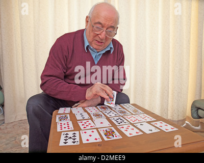 ältere Menschen sitzen Mann Spielkarten auf eigene Faust Stockfoto