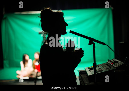 Eine Frau sprechen in das Mikrofon in einer gemischten / multimedia video Theateraufführung wirkenden live-Art, Aberystwyth University, UK Stockfoto