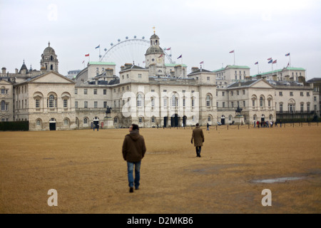 Besucher gehen über die Horse Guards Parade mit dem berühmten London Eye und dem historischen Horse Guards Gebäude im Hintergrund, London, England Stockfoto