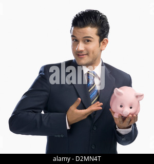 Geschäftsmann hält ein Sparschwein Stockfoto