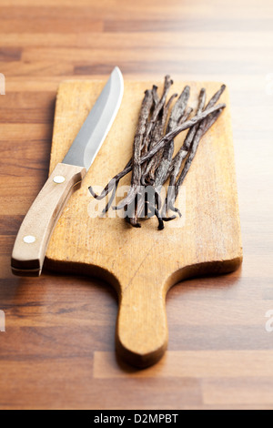 Vanilleschoten mit Messer auf Holztisch Stockfoto