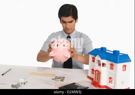 Immobilienmakler in ein Sparschwein Stockfoto