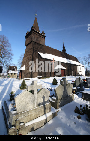 Eine sehr alte hölzerne Kirche auf einem Hügel an einem schönen sonnigen Wintertag. Stockfoto