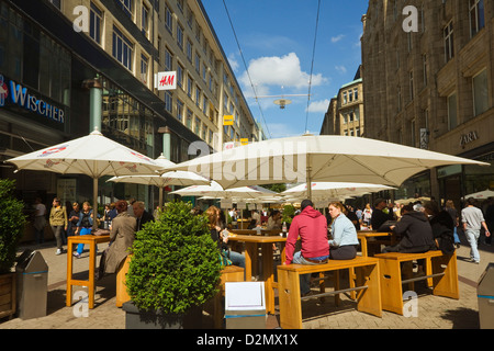 Leute sitzen "al Fresco" unter den Sonnenschirmen vor Restaurant auf Pedestriansed shopping Straße Spitalerstraße, Hamburg, Deutschland Stockfoto