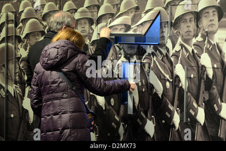 Besucher betrachten eine Wand mit Fotos von Soldaten der NVA, die Armee der DDR, in das DDR-Museum (DDR-Museum) in Berlin, Deutschland, 30. November 2012. Das DDR Museum zeigt eine interaktive Dauerausstellung der Alltag und Kultur in der DDR. Seit seiner Eröffnung im Juli 2006 wurde das Museum sehr beliebt bei Touristen. Zwischen 2008 und 2012 wurde es auch für das Europäische Museum des Jahres nominiert. Foto: Jens Kalaene Stockfoto