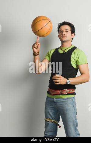 Porträt eines Mannes einen Basketball auf der Fingerspitze Abwägung Stockfoto