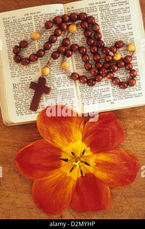 Bibel und Gebet-Buch öffnen an der Psalmen mit Perlen Kruzifix Anhänger und rote und gelbe Tulpe Blume Stockfoto