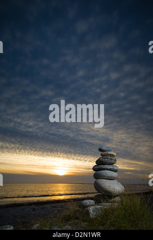 Kiesel-Skulptur am Strand. mit einem Abendhimmel und sanften Sonnenuntergang. Stockfoto