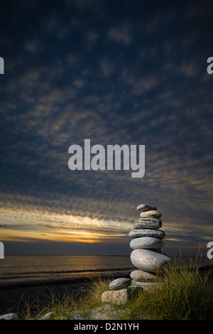 Kiesel-Skulptur am Strand. mit einem Abendhimmel und sanften Sonnenuntergang. Stockfoto