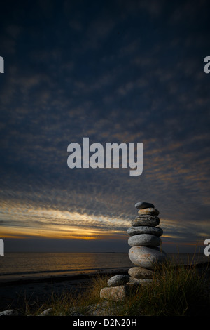 Kiesel-Skulptur am Strand. mit einem Abendhimmel und sanften Sonnenuntergang. Stockfoto