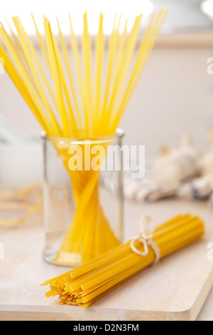 Getrocknete Tagliatelle Nudeln auf Holztisch in der Küche Stockfoto