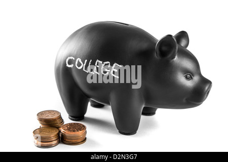 Schwarzes Sparschwein auf weißem Hintergrund mit "College" geschrieben und drei Stapel von 2 Pence Münzen Stockfoto
