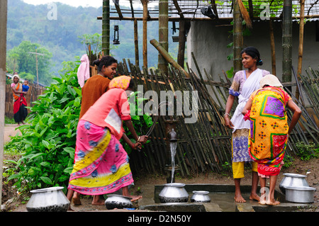Frauen, die Pumpen von Wasser aus einer Hand-Pumpe, Jorhat, Assam, Indien, Asien Stockfoto