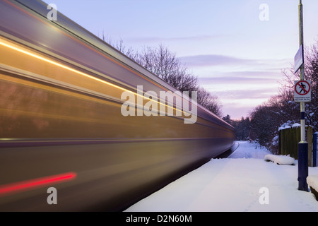 Erster Zug von Middlesbrough nach Whitby auf der malerischen Esk Valley Linie verlassen Schnee bedeckten Kildale Bahnhof bei Sonnenaufgang. Stockfoto