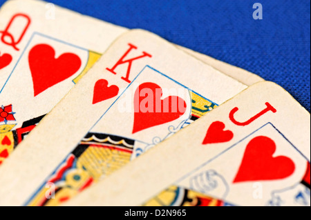 Nahaufnahme von drei Spielkarten - Bube, Dame und Jack of Hearts auf blauem Hintergrund Stockfoto