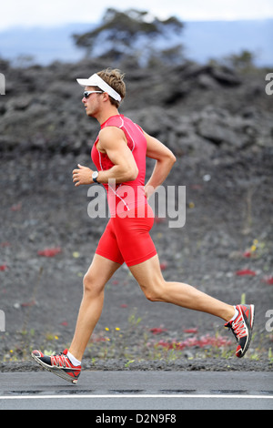 Voller Länge Seitenansicht des jungen männlichen Athleten im roten Kompression oben laufen auf Vulkan auf Big Island, Hawaii Stockfoto