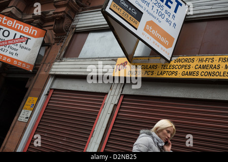 Heruntergekommenen Straßen, lassen Sie Zeichen und verschalten von Geschäften in der Stadt Zentrum in Glasgow, Schottland, Großbritannien, 2013. Stockfoto