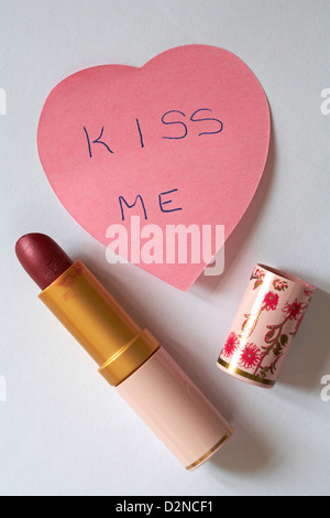 Kiss me Nachricht auf Rosa herzförmige Post geschrieben es Notizen mit Lippenstift auf weißem Hintergrund Stockfoto