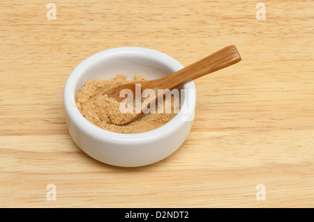 Gemahlener Ingwer in ein Töpfchen auf einem Holzbrett Stockfoto