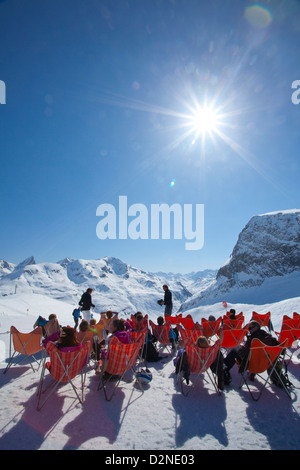 Skifahrer entspannend vor einem Bergrestaurant hoch über Zürs, Arlberg, Österreich. Stockfoto