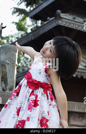 Eine helle glücklich kleine Asiatin war Dancing vor tibetischen Tempel am Southbank, Brisbane Stockfoto