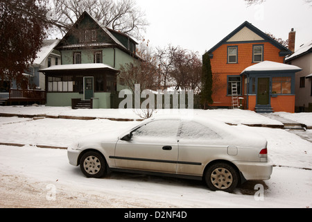 Auto im Schnee geparkt an der Seite von der Straße vor Wohnhäusern Caswell Hügel Saskatoon Saskatchewan Kanada bedeckt Stockfoto