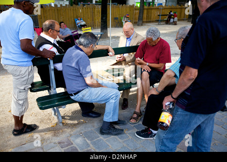 Männer zu sammeln, während ein Spätsommer-Nachmittag für eine Partie Domino in Paris, Frankreich Stockfoto