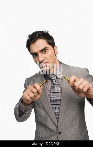 Porträt eines Geschäftsmannes brechen einen Bleistift Stockfoto
