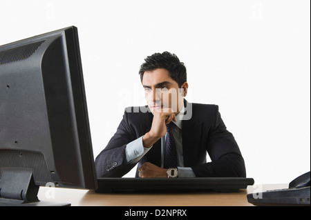 Geschäftsmann am Computer suchen und dachte Stockfoto